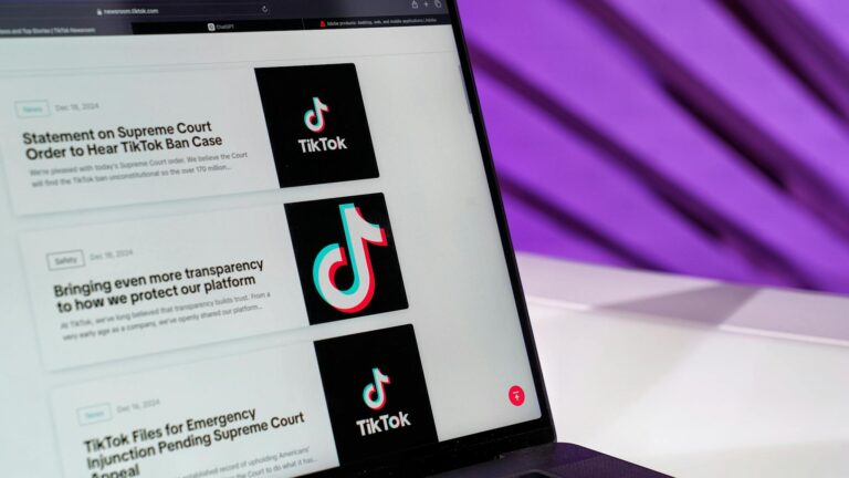 Close-up of laptop screen showing TikTok news articles with a purple background.